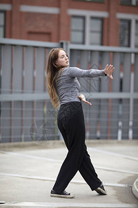 城市街上一位女舞者在运动的肖像跌倒了背景图片