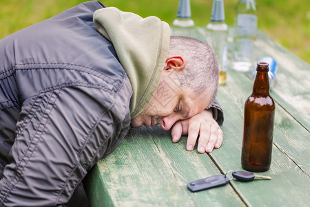 户外酒瓶附近的醉汉背景图片