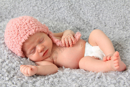 穿着粉红色编织帽子的十天婴儿女婴睡图片