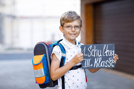 戴着眼镜和背包或书包的快乐小男孩上学路上的小学生户外健康可爱的孩子在德文三年级第一天的桌子图片