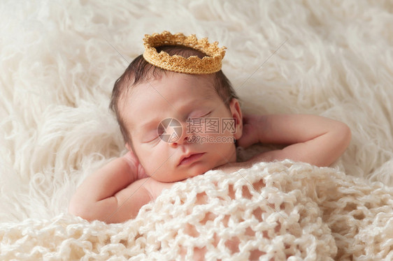 一名12天大的身戴金冠的新生儿男孩的肖像他睡在米格罗卡蒂地毯上图片