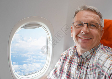 中年英俊男子坐在窗户旁边的飞图片