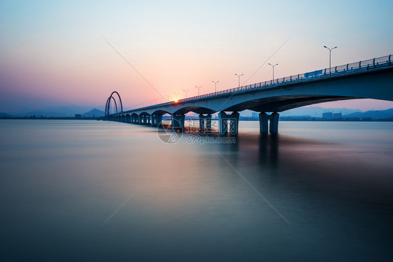 日出日落天际线和河上的桥梁图片