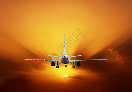 飞机对着彩色的夕阳天空图片