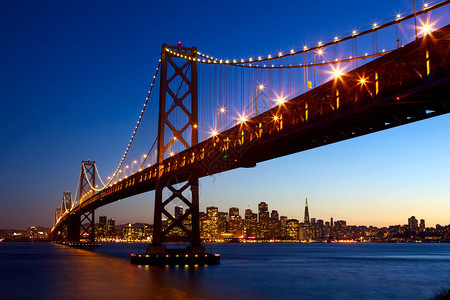 旧金山天际和日落时湾桥美国加利福尼亚图片