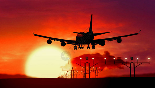 Jumbo喷气式飞机在日落时空降落在机场图片