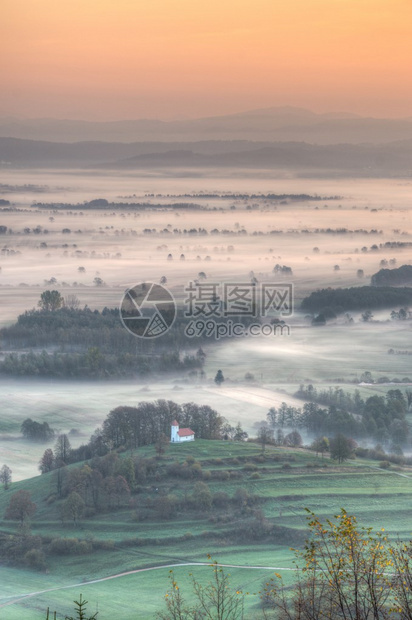 空中观视山丘和教堂晨雾在图片