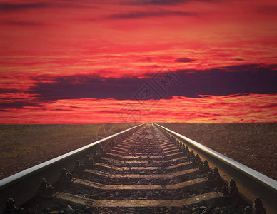 铁轨驶入深红色的日落铁轨随着火红的日落驶图片