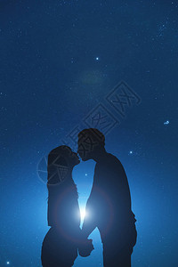 星空下一对年轻夫妇的剪影图片