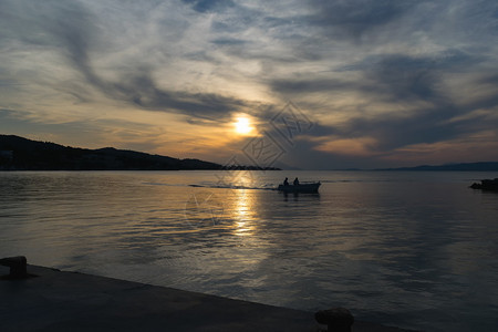 渔船剪影返回港口反对戏剧天空背景图片
