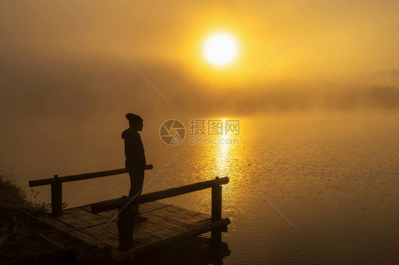 日出时分站在船屋河湖上的剪影抑郁男子图片