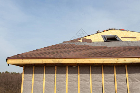 屋顶建筑和建造带有天窗阁楼天窗和屋檐的新砖房修理室外屋顶上的沥图片