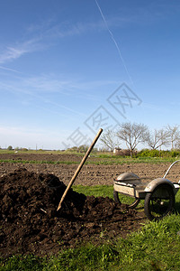 用有机肥料堆和独轮车看花园的春景图片