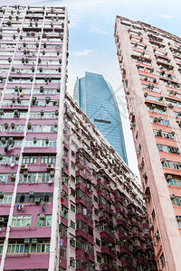 一座现代摩天大楼耸立在香港鲗鱼涌旧住宅区拥挤的住宅区之上图片