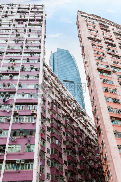 一座现代摩天大楼耸立在香港鲗鱼涌旧住宅区拥挤的住宅区之上图片