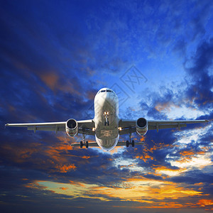 客机准备降落在美丽的昏暗天空中用于旅游业和图片