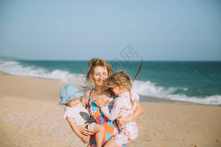 年轻母亲和可爱的小女儿在沙图片