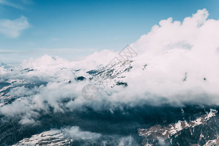 美丽的阿尔卑斯山地貌雪积的山峰和云层黑月图片