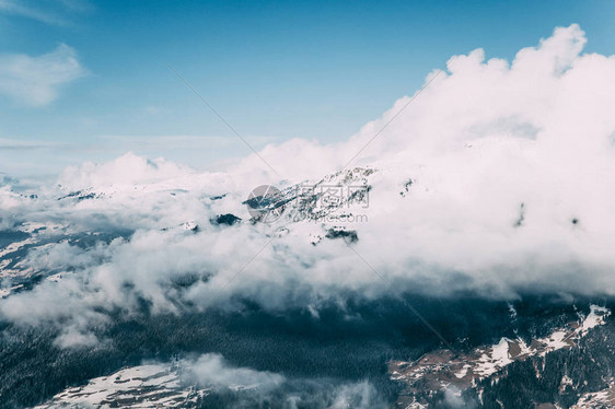 美丽的阿尔卑斯山地貌雪积的山峰和云层黑月图片