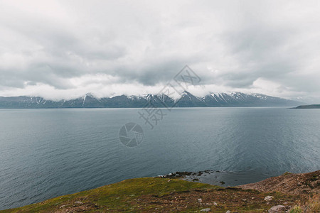 美丽的落基山脉冰岛的雪和海边图片