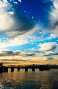日落时渡轮驶入码头与奥运山对面的图片