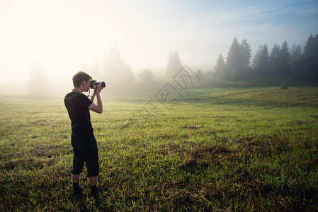 摄影师在雾中拍摄风景图片