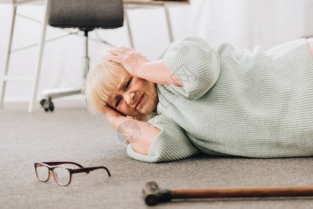 无助无助的退休妇女头痛时躺图片