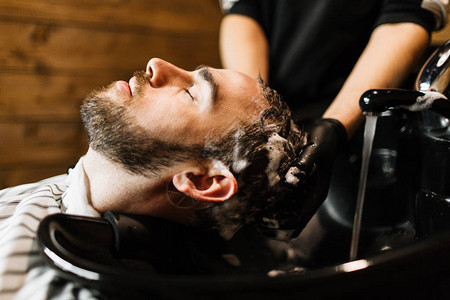 理发师在洗头时在客户头发上起泡沫图片