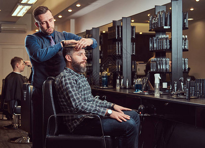 一位时尚的理发师为客户理发理发店的男士理发用图片