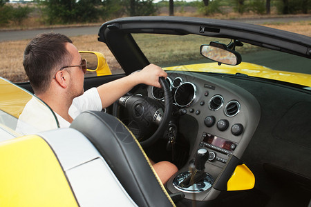 时尚男子驾驶黄色的出租车图片