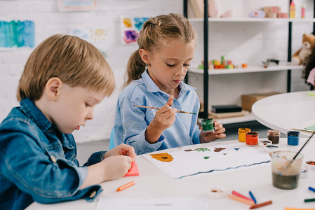 油画长城重点突出的学龄前儿童在课堂上用桌边的油漆和油背景