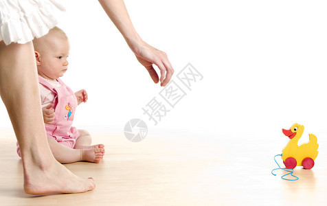 有玩具的女婴坐在地板上图片
