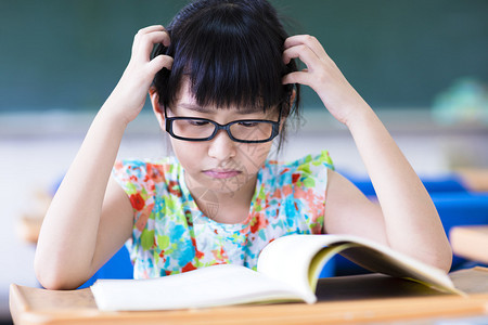 在教室学习的沮丧的小女孩背景图片