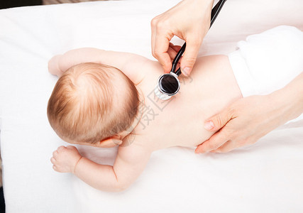 儿科医生在检查室检查三个月的女婴医生用听诊器听婴儿的图片