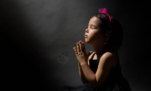 小女孩祈祷孤立的黑人背景与世隔图片