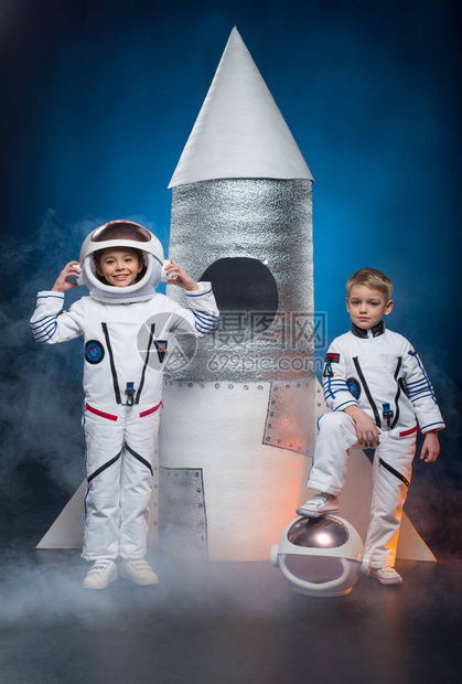 身着宇航员服装的男女小男孩女站在火箭附近图片