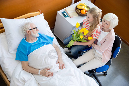 外祖母和孙女带郁金香花到医院看病男病人在医图片