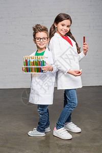 身穿实验室大衣的小孩拿着试管带着试剂图片