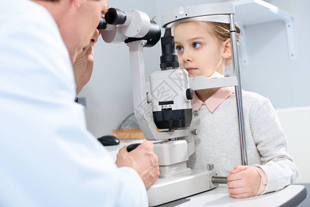 眼科医生检查青春期前儿童视力在诊所图片