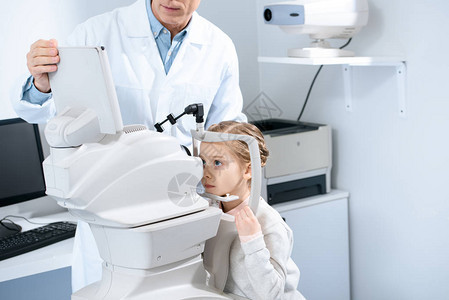 眼科医生在诊所检查青春期前儿童视力的作物形图片