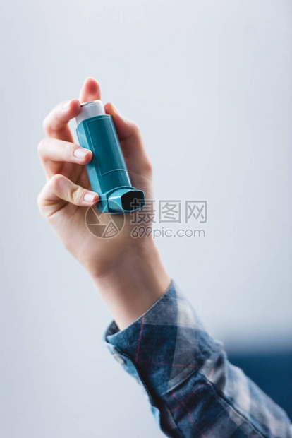 年轻女子手持哮喘吸入器的特写部分视图图片