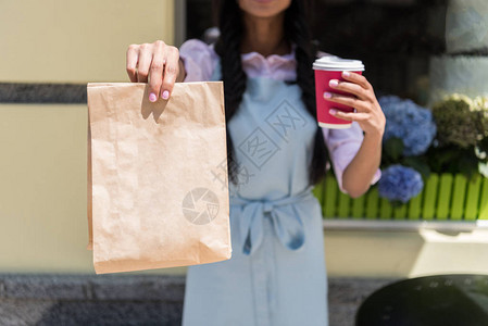 手持纸袋和一次杯子的女服务图片