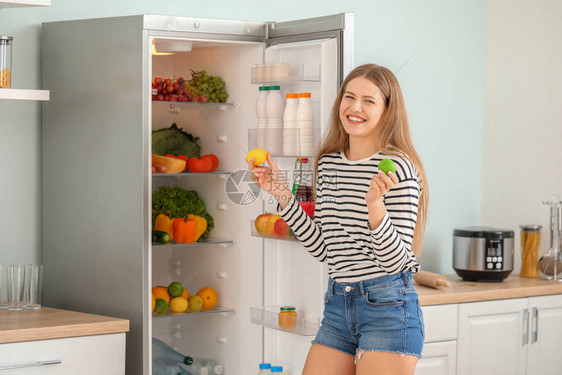 女人从家里的冰箱里拿出食物图片