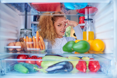 女人站在打开的冰箱前图片
