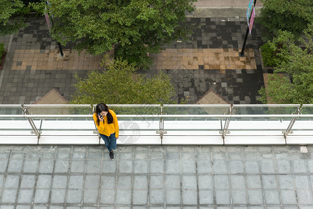 亚洲年轻女在街上走在街上与手机交图片
