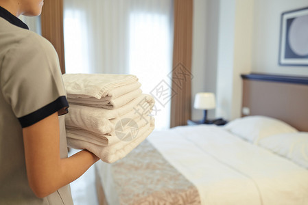 酒店女佣在酒店房间里带来干净的毛巾图片