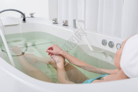 在温泉沙龙洗澡时放松的年轻女头部毛图片