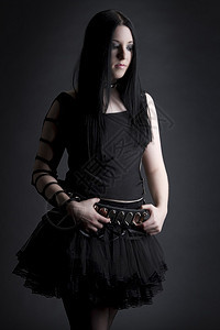 一头黑发哥特风格穿着黑色短裙用拇指握着腰带表图片