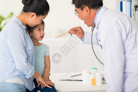 医生要求小女孩张嘴检查她的喉图片