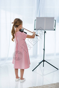 在家里玩小提琴时穿着粉红裙图片